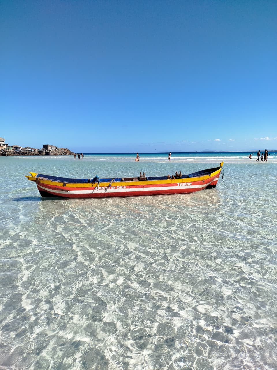 Barco tradicional navegando em águas rasas de Arraial do Cabo