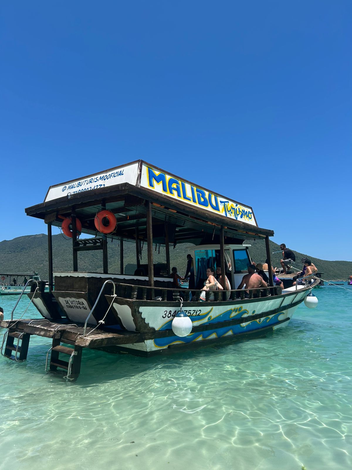Barco de turismo ancorado em águas claras junto ao território